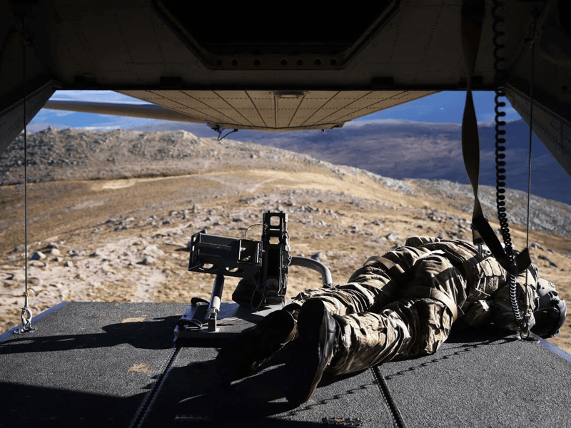 Aircrewman working inside of a Merlin Mk4 helicopter during mountain flying training.