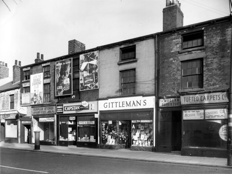 North Street in October 1962. On the left edge is number 210, a vacant shop which had been S and G Stores. Next, the entrance to Jack Ash, bookmakers premises can be seen. Moving right, 208 is an Army Surplus Store, then 106 Cooke's grocers and delicatessen. Gittleman's gentlemens outfitter is next at 104. On the right, Modern Floorcovering is 202.