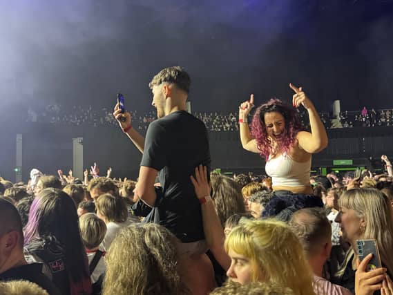 A couple of fans attempt to get a better view of the stage.