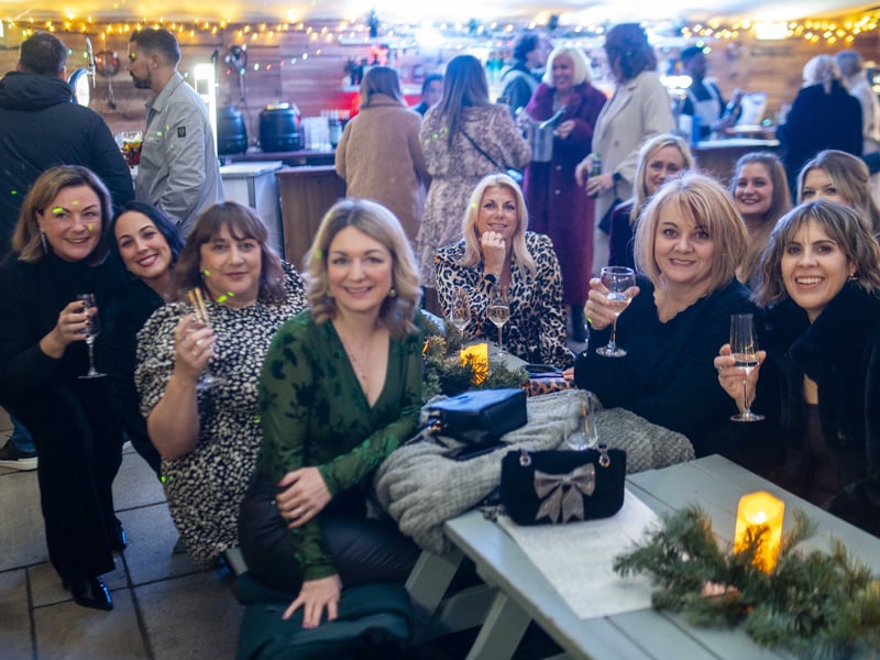 Friends gather inside the Winter Lodge at the Queen's Hotel