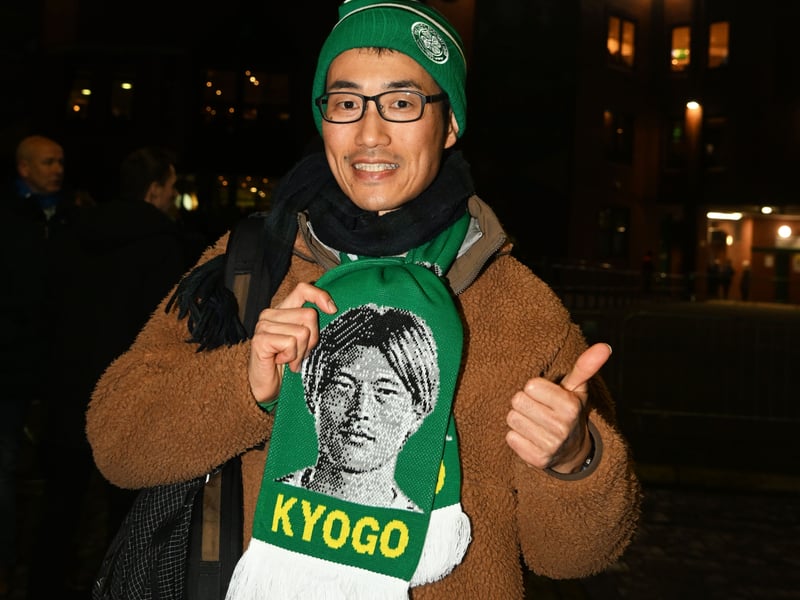 A Celtic supporter shows off his Kyogo scarf ahead of the game.