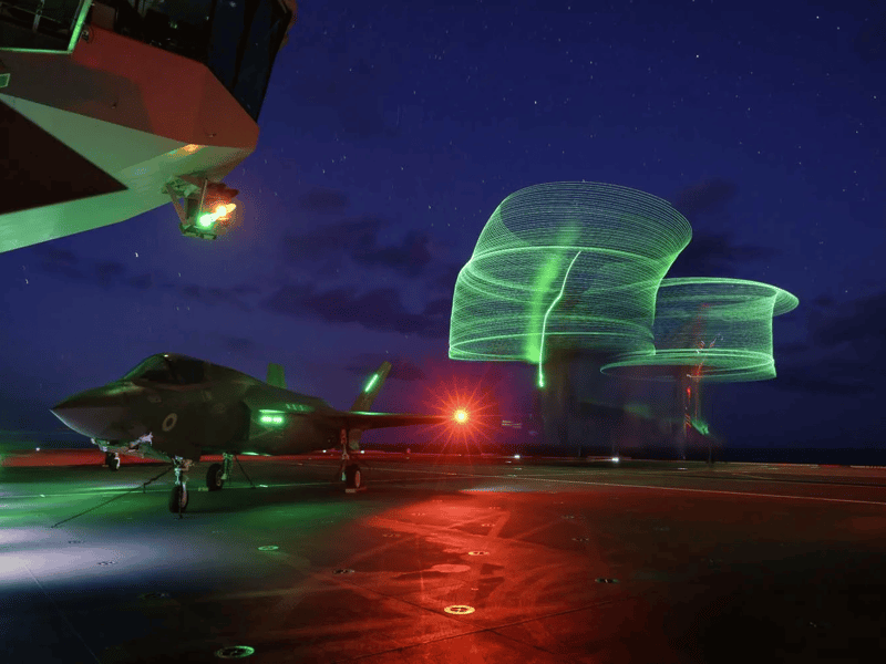 A long exposure image of a CV-22B Osprey taking off from HMS Queen Elizabeth, culminating in a night flying operation.