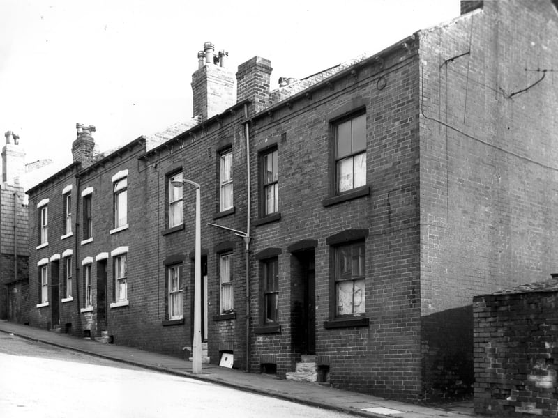 A row of four double fronted back-to-back terraced houses flanked by shared outside toilet yards in Silver Royd Grove. Pictured in October 1968.