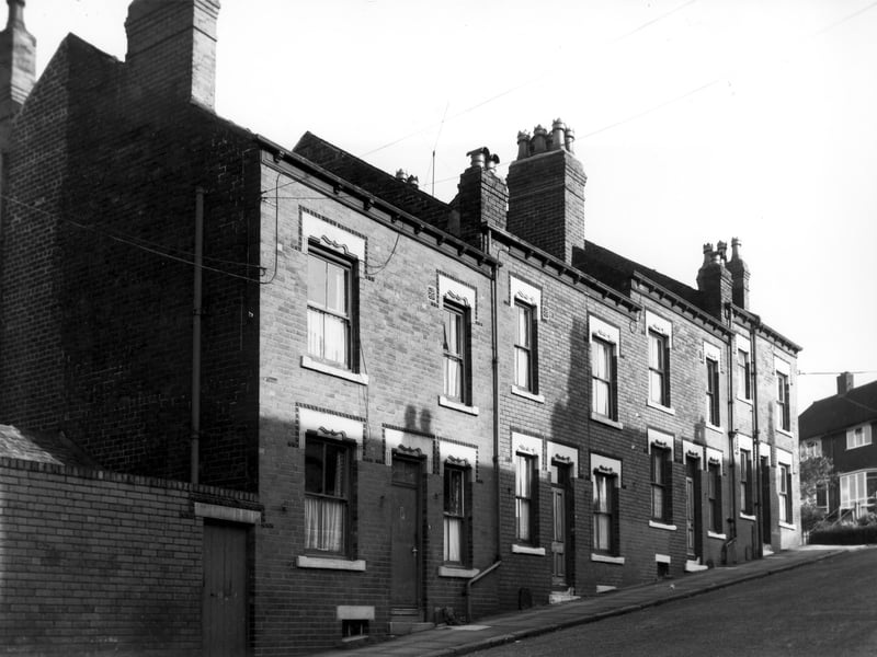 A row of double fronted back-to-back terraced houses with a shared outside toilet yard on the left on Silber Royd Avenue. Silver Royd Road is on the right. Pictured in October 1968.
