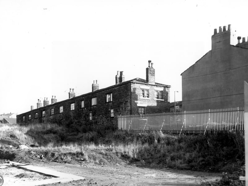 The rear of through by light terraced houses numbers 15 to 31 Scott Square. On the right is the gable end of number 13 Scott Square.
