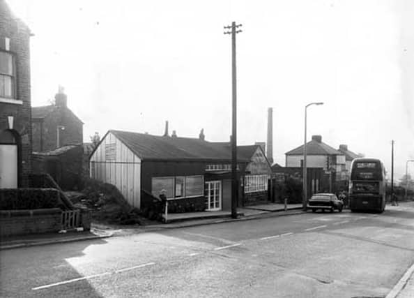 Tong Road in October 1968. In focus is Joseph Tate funeral directors, in business for five generations. Behind can be seen the Barchester Ales Brewery while on the right a number of people queue to get on the number 11 bus to Greenthorpes.