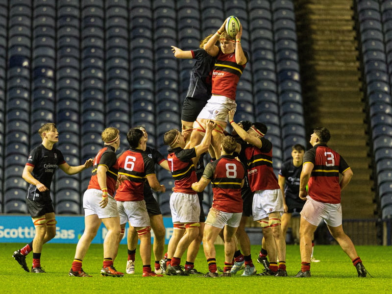 Match action between Stewart's Melville College (red with black) and Merchiston Castle School during the Under-18 Schools Cup final at Murrayfield.