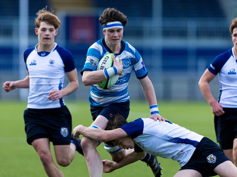 Match action between Edinburgh Academy (light blue and white hoops) and Dollar Academy during the Under-16 shield final.