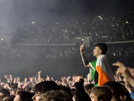 A fan pops up on a friend's shouders to take a picture.
