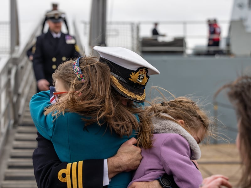 Commanding Officer Commander Daniel Lee (40) with daughters Jemima (9) and Abigail (8). HMS Duncan conducted a Christmas homecoming from the Mediterranean in December 2024.