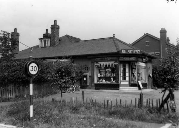 Adel Post Office at the junction of Otley Road and the Crescent, business of Fredrick Sidney Smith. Single storey building extension of adjoining bungalow. A post box is on the left wall. A road sign for 30 mile per hour speed limit is also to the left. Pictured in July 1936.