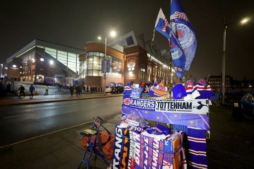 Commemorative scarves are sold outside of Ibrox before the game.