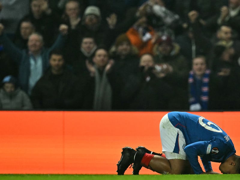 Hamza Igamane celebrates scoring the team's first goal as Rangers fans watch on.