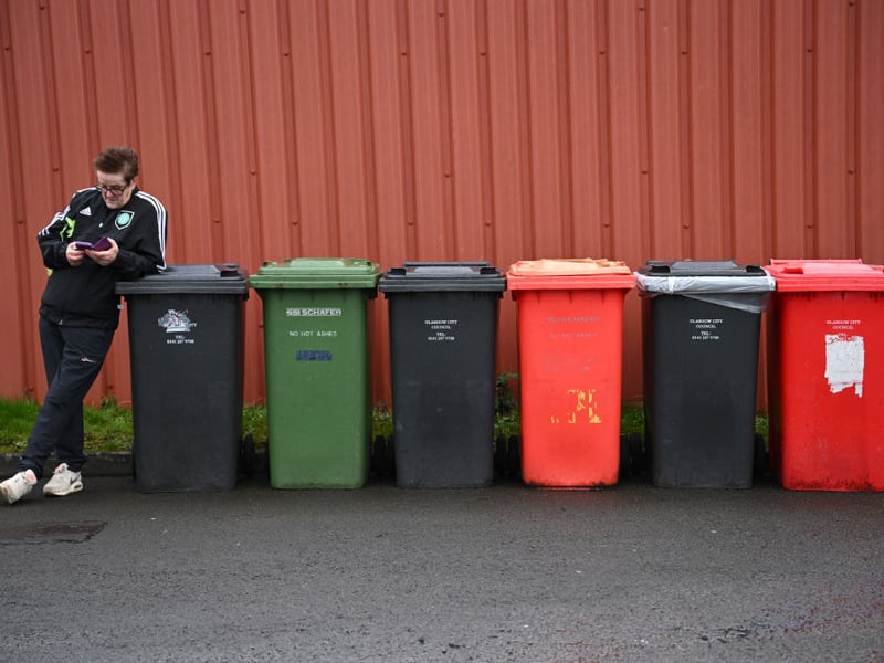 A Celtic fan checks their phone outside the stadium prior to the Premier Sports Cup Final.