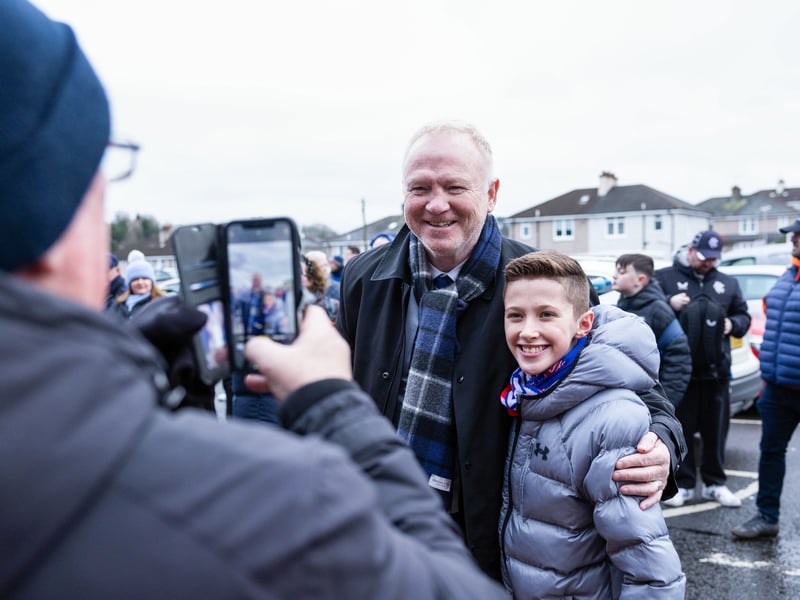 Former Rangers manager Alex McLeish takes a photo with a young fan ahead of the game against Celtic.