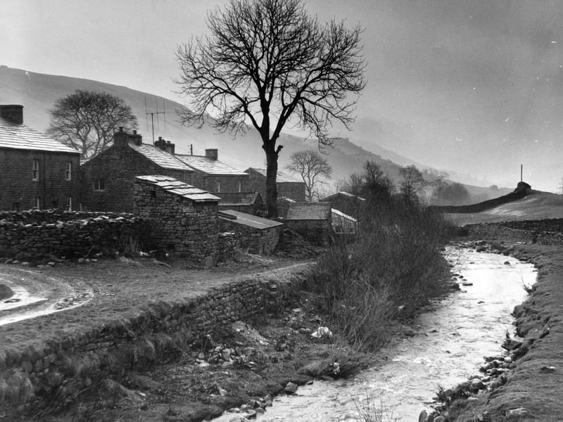 Mists rise over the Swaledale hamlet of Thwaite with Muker Beck in the foreground in April 1969.