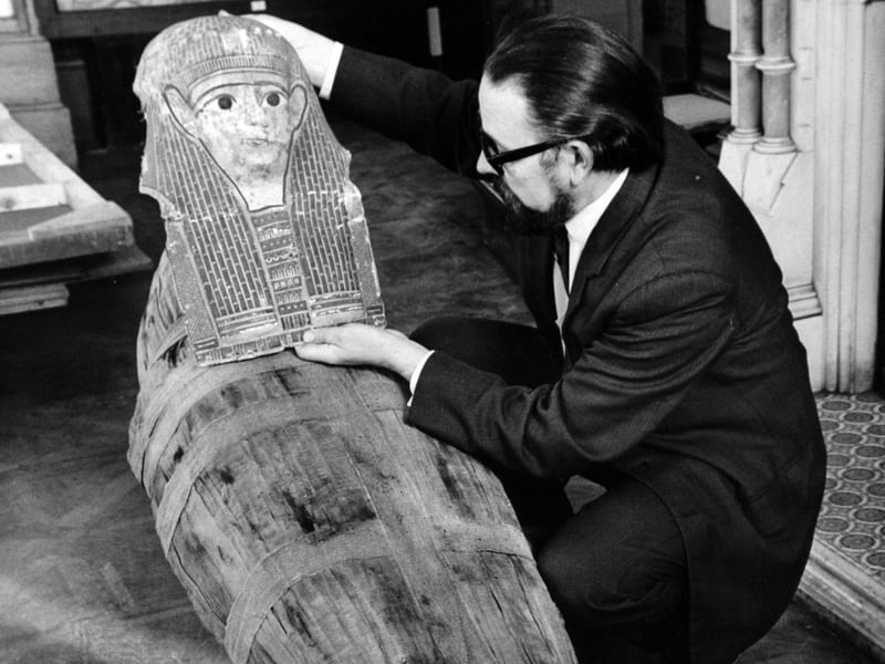 With the aid of a 2,000-year-old funeral mask, several rolls of bandages, wire netting, hardboard and powdered coffee, a museum expert had produced a realistic-looking mummy. The construction of this modern mummy was a serious venture carried out to provide the centre-piece for a display of ancient Egyptian antiques which will be a feature of Bagshaw Museum Pictured in November 1969 is curator John Lidster.