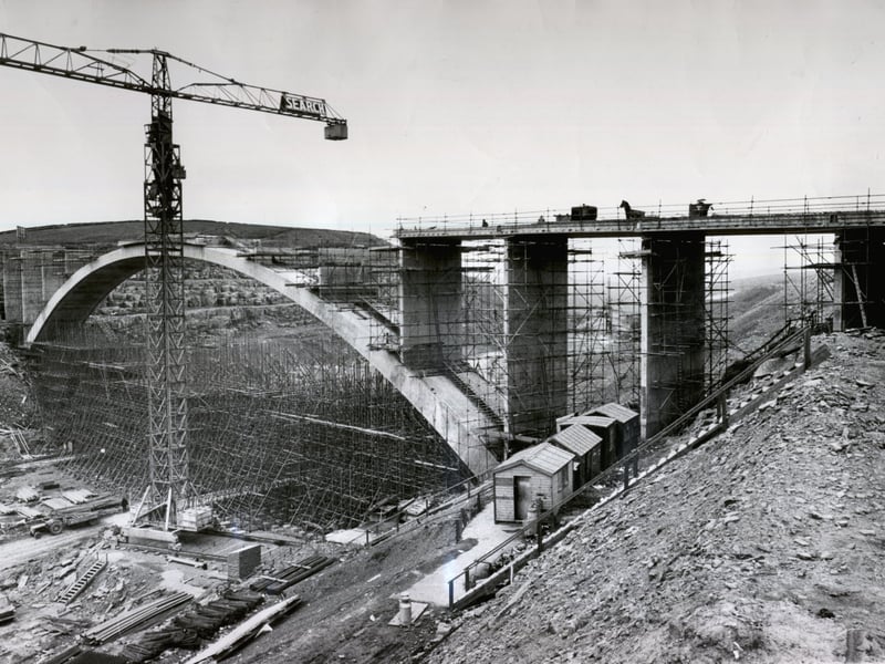 July 1969 and slowly the graceful arch of the new bridge emerges above its web of scaffolding to span the gap torn in the Scammonden Valley for the M62 motorway.
