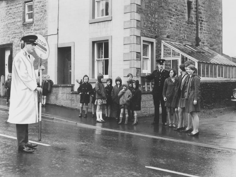 Sixth former Paul Bradbury from Bentham Grammar School on crossing patrol duty watched by police constable George Marshall, right, who was also giving advice to other sixth formers. Pictured in May 1969.