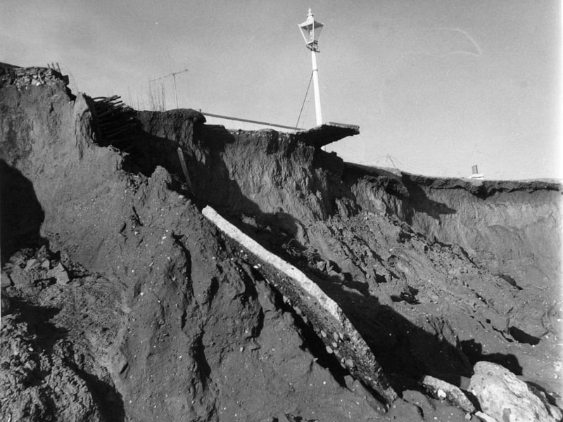 January 1969 and a lamp post is inches from the cliff edge, and part of a garden path is suspended in the air after coast erosion caused by heavy seas.