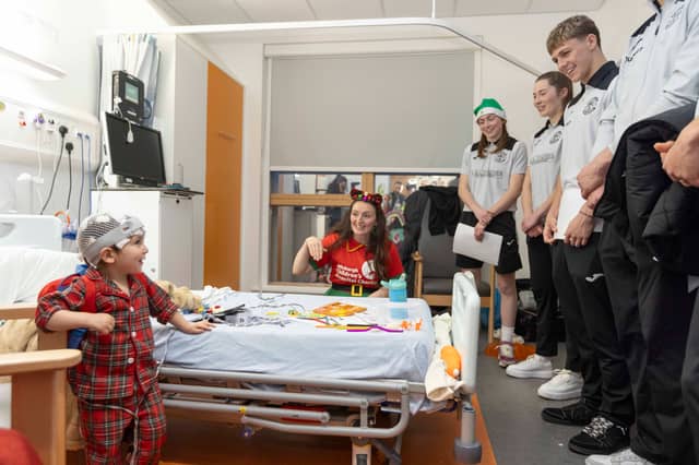 Aren't you guys a little big to be elves? This young patient seems surprised AND delighted by her visitors.