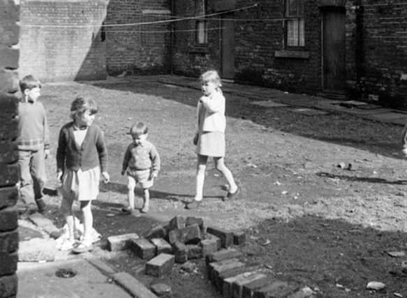 Children play on an unmade road on Back Barker Square in April 1969.