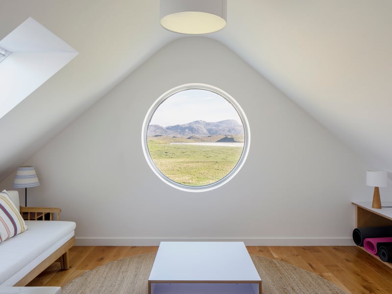 Porthole windows upstairs keep the views open while creating a snug little space. 