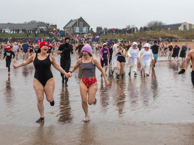 Swimmers braved strong winds and rain to take part in the annual St Andrews New Year Dook on East Sands