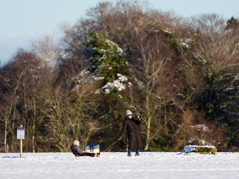 A youngster is pulled along in a sledge.