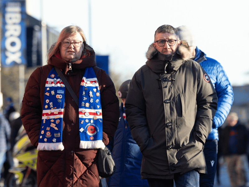 Two fans make their way to the game on Thursday's game between Rangers and Celtic.