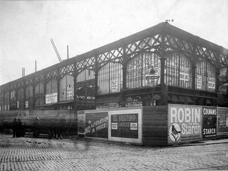 The old market hall surrounded by advertising boards taken prior to demolition in June 1901.. The hall was replaced by a new market hall designed by Leeming and Leeming of Halifax at a cost of £80,000 and opened in July 1st 1904.