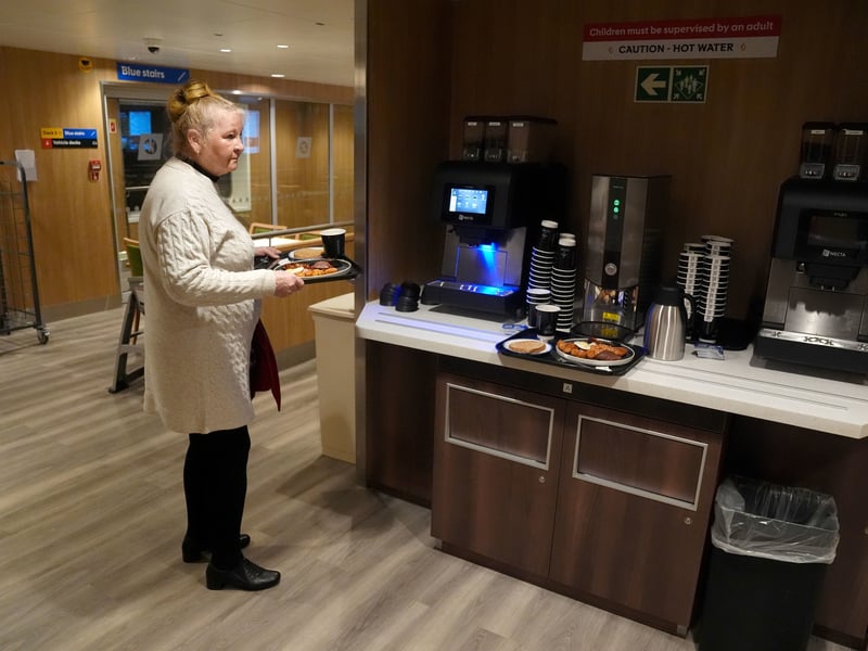 A passenger gets a cup of coffee and some food onboard the Glen Sannox ferry as it journeys from Troon to Brodick on Isle of Arran on its first official day in service.