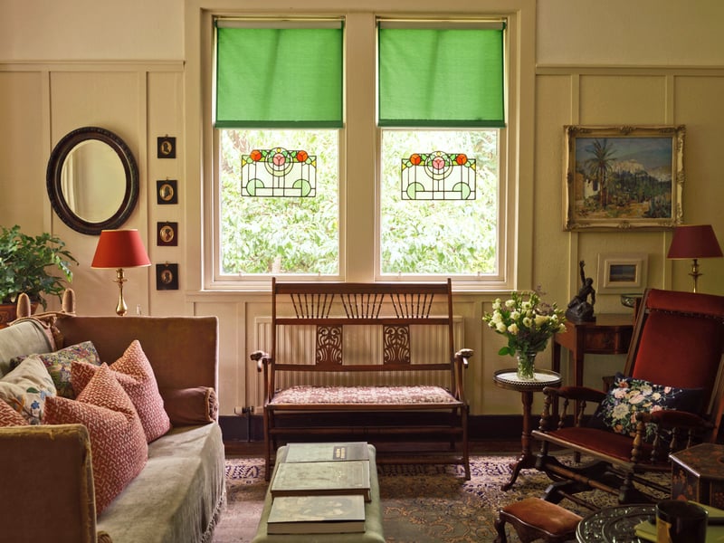 The living room with restored stained glass windows and period furniture