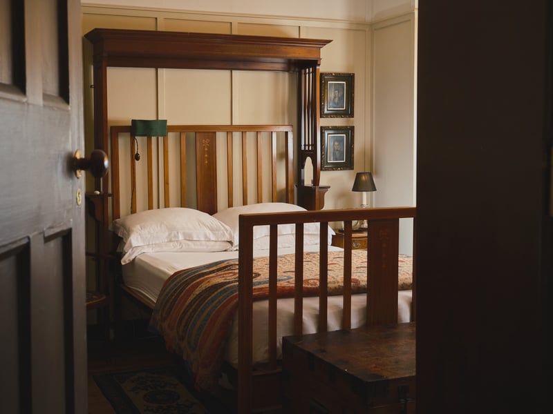 The main bedroom with grand mahogany bed and wood panelling