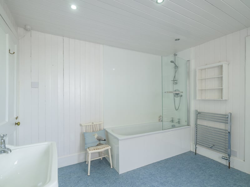 One of the home's three bathrooms, with white wooden panel walls