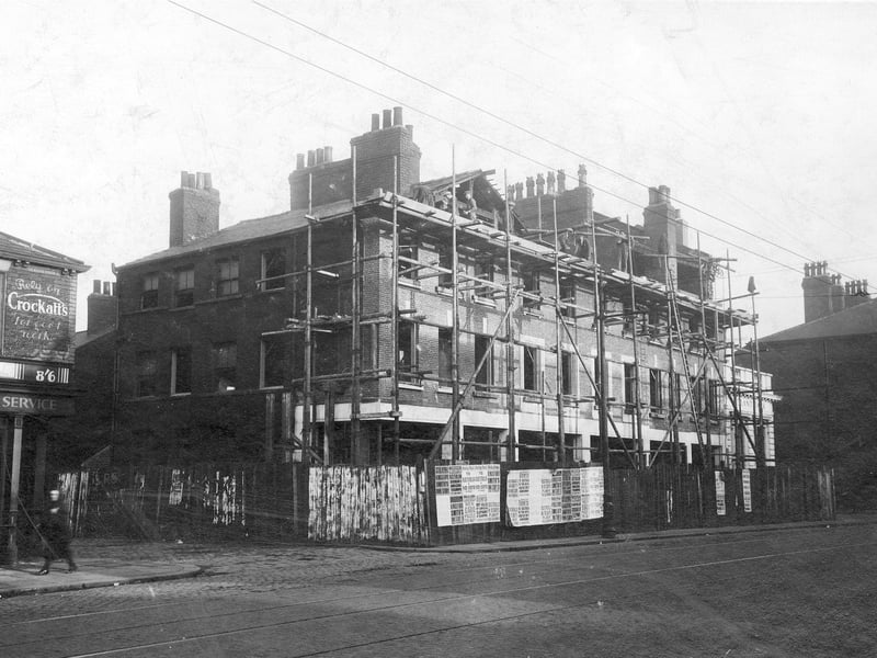 Hunslet Road in October 1930. Tbis view is from the junction with Pitfield Street looking down towards Stafford Street. Scaffolding up at the shops which are being altered. Various posters have been put on the fence showing the headlines from different newspapers.