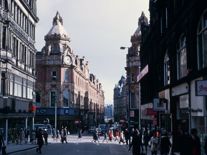 A busy Albion Place looking east across Briggate towards King Edward Street in March 1975. On the left are Hornes and Dunn & Co., both menswear shops. On the right is Bailey's, another menswear shop, then a vacant shop previously occupied by Marcus Price, also menswear. This is followed by Cyril Livingstone, ladieswear, P. Jones, china and glass, the Brook Street Bureau employment agency and Dolcis footwear.