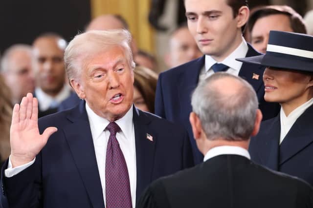 U.S. President Donald Trump takes the oath of office as Barron Trump and Melania Trump look on.