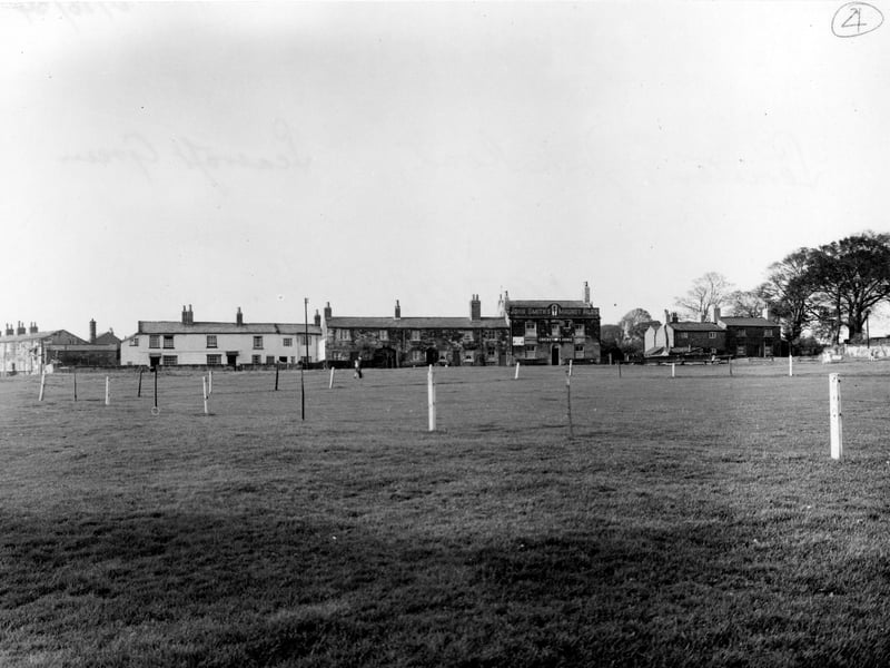 Looking North-West across The Green towards The Cricketer's Arms. The Green's cricket pitch is roped off. The pub has a sign for John Smith's Magnet Ales. Pictured in October 1954.