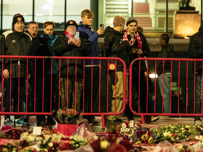 Manchester United fans pay tribute to the late, great Scottish legend Denis Law at the United Trinity statue.