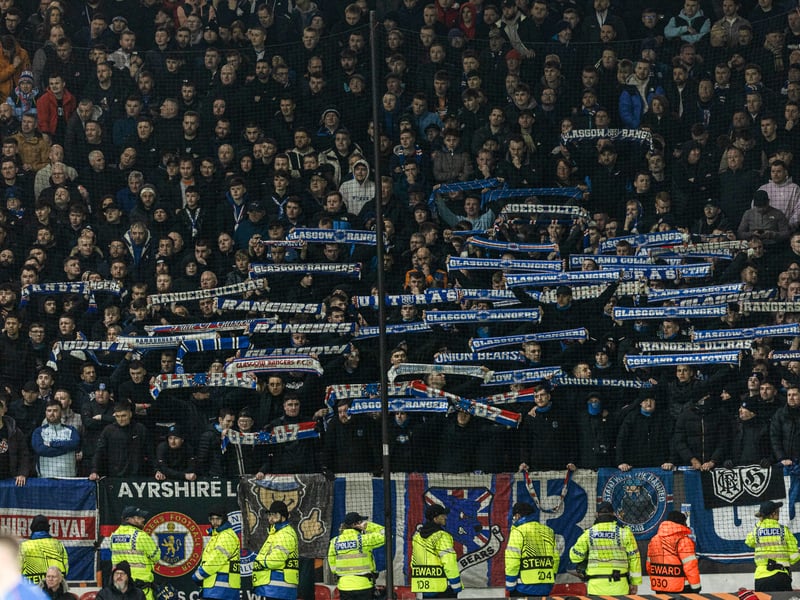 Rangers fans raise their scarves in the away end.