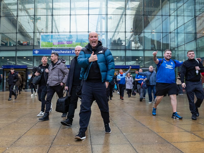 A Rangers fans show his delight at arriving into Piccadilly Station for the game.