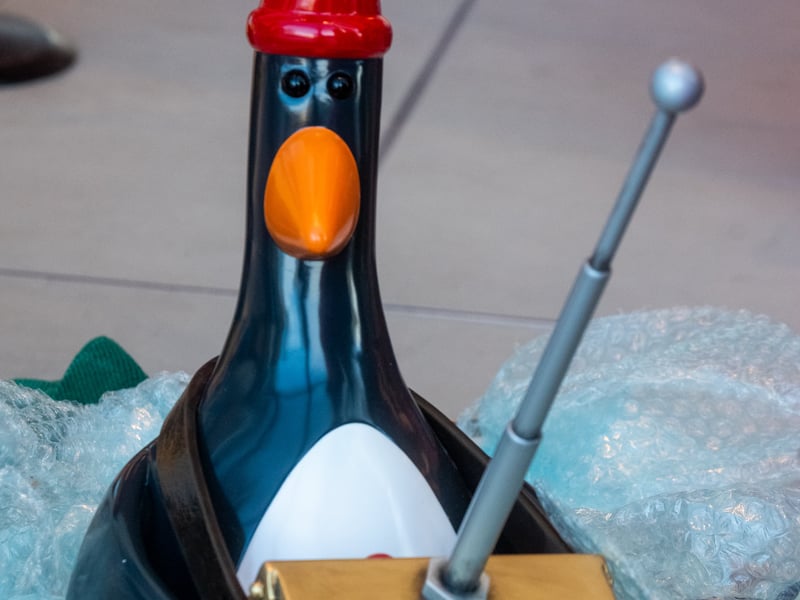 The model features the Techno Trousers and the infamous penguin villain, Feathers McGraw, scaling the museum’s wall above the welcome desk. Pictured is Andy Spradbery, model maker for Aardman, holding Feathers McGraw before it is positioned atop the Techno Trousers. 