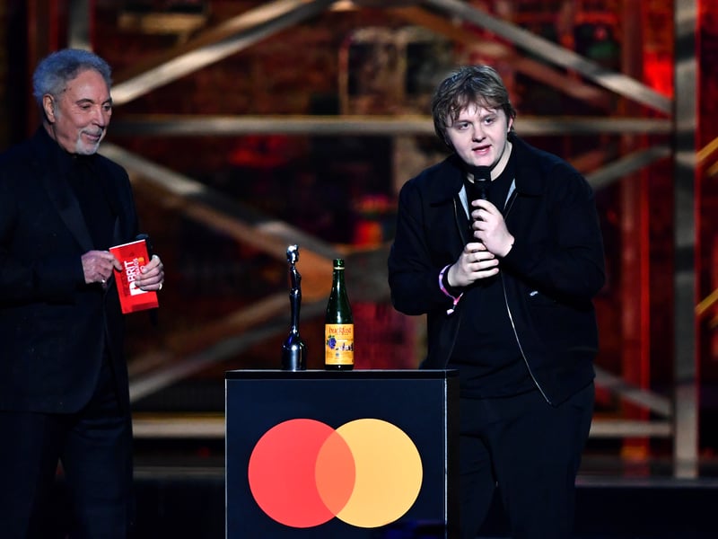 Lewis Capaldi brought his signature humour to the BRITs, from sipping from a bottle of Buckfast on stage to flipping off the camera in response to tabloid rumours. His casual, relatable demeanour contrasted with the usual glitz of the awards, making him a fan favourite.