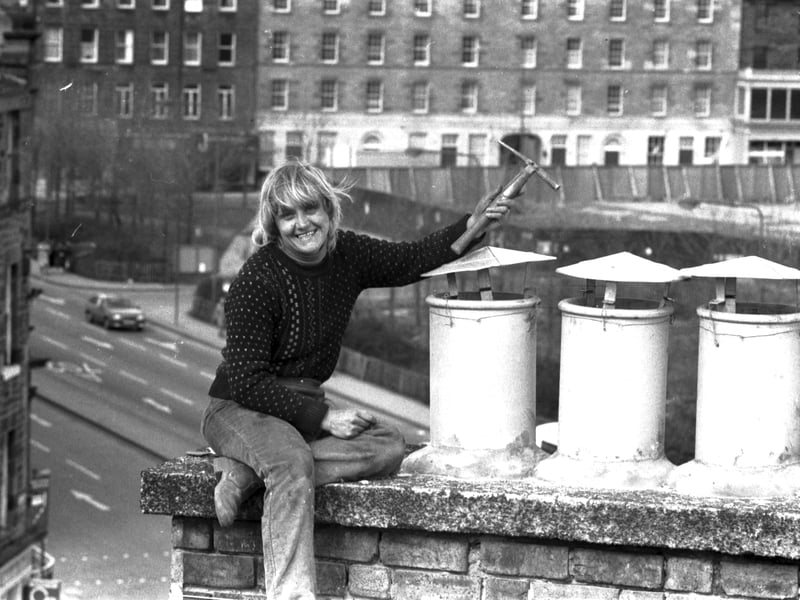 Female slater Betty Black repairing roofing slates among the chimney pots on an Edinburgh building in March 1985.