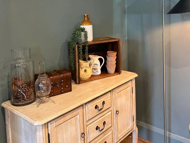 A vintage-style dresser and artwork adorning walls channels a pretty cottage-core aesthetic