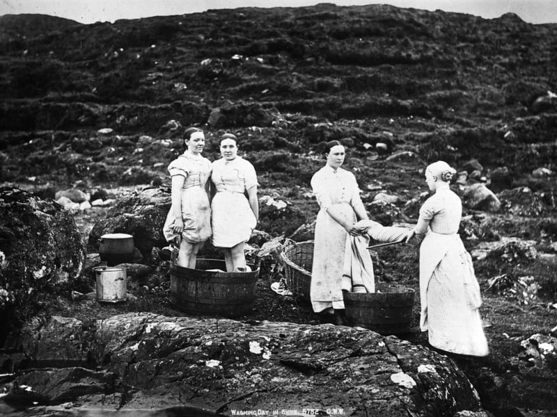 circa 1910: Women on Skye washing their clothes in a stream on the hillside.