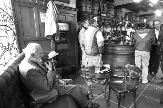 An old man smoking his pipe in the traditional pub Ryrie's at Haymarket in Edinburgh, March 1993