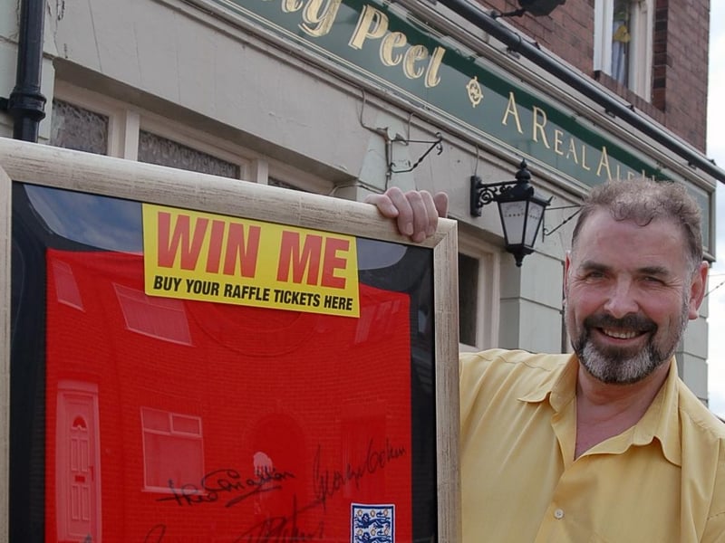 The pub was raising money in 2006. Here is bar worker Ian Smith with a signed 1966 England shirt.