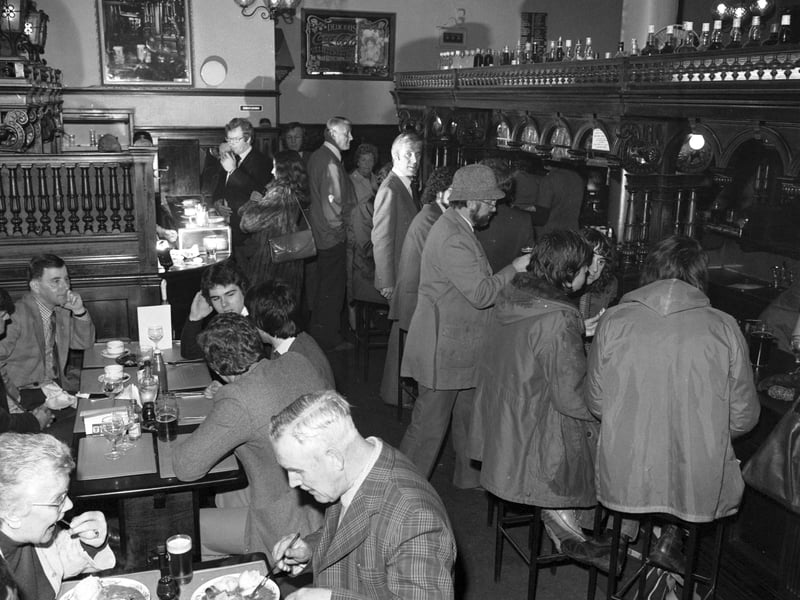 Customers having a drink and a bar lunch in the Abbotsford bar in Rose Street Edinburgh.